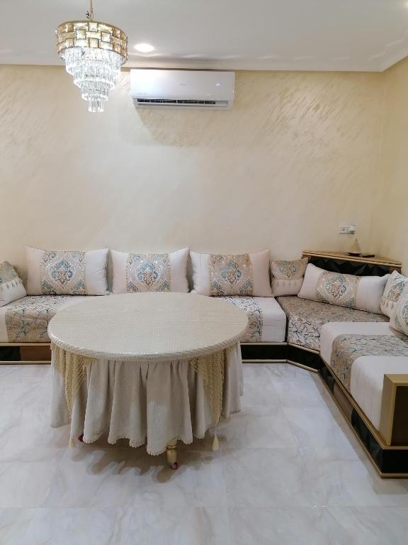 a living room with a couch and a table at Résidences nour nador in Nador