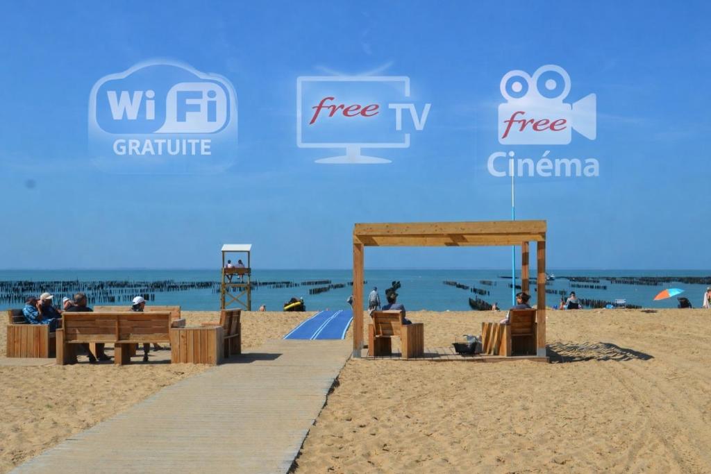 a wooden boardwalk on the beach with people on it at Évasion en Bord de Mer Maison Tout Confort à La Faute-sur-Mer in La Faute-sur-Mer