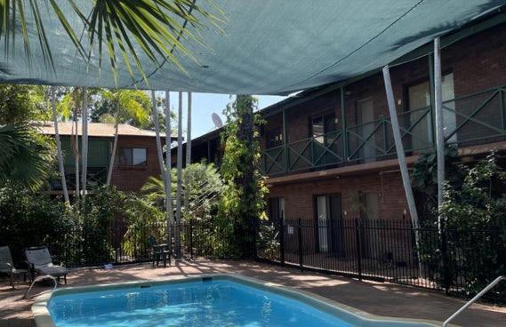 a house with a swimming pool in front of a building at Pearlers Lodge in Broome