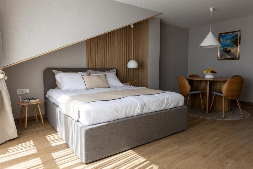 a bedroom with a large bed and a table at Horizon 180 in Varna City