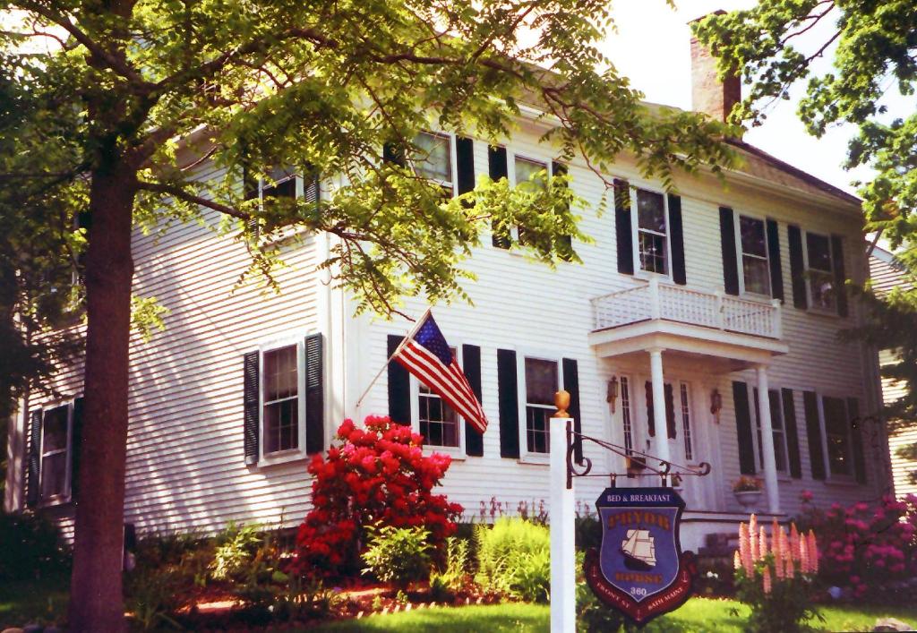 Uma casa branca com uma bandeira americana à frente. em Pryor House B&B em Bath