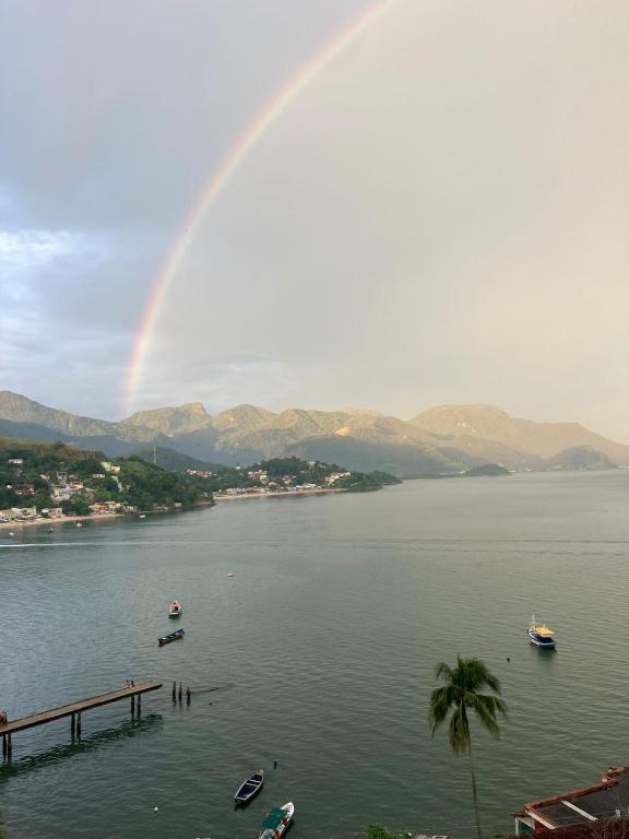 a rainbow over a body of water with boats at Recanto Vista Mar - Costa Verde, Mangaratiba in Mangaratiba