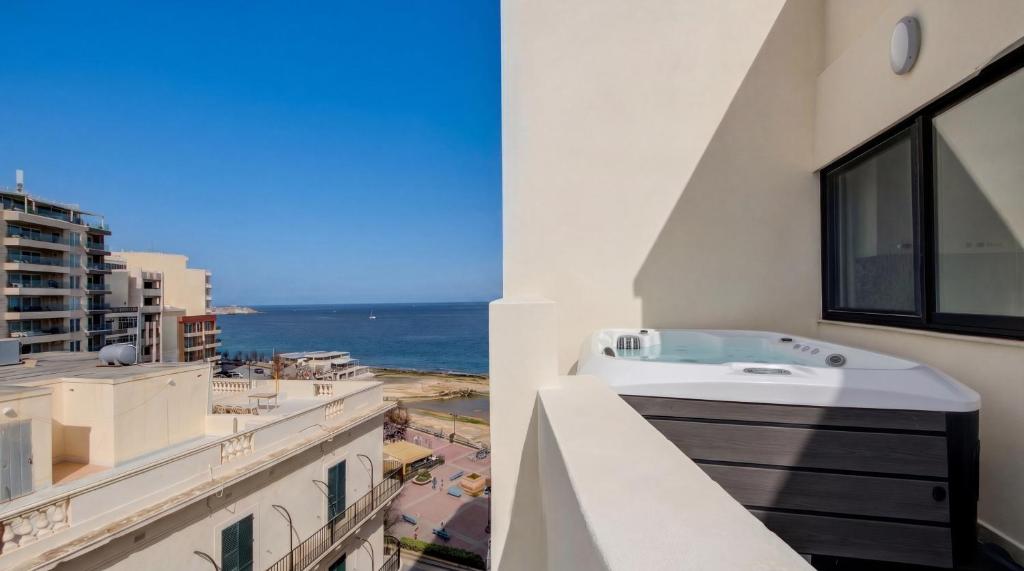 a balcony with a bath tub and a view of the ocean at Sliema Seaview 4BD Apartments & Penthouse with Jacuzzi in Sliema