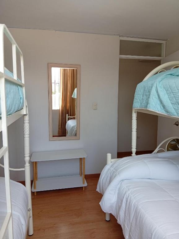 a bedroom with two bunk beds and a mirror at villa hermosa cayma in Yanahuara