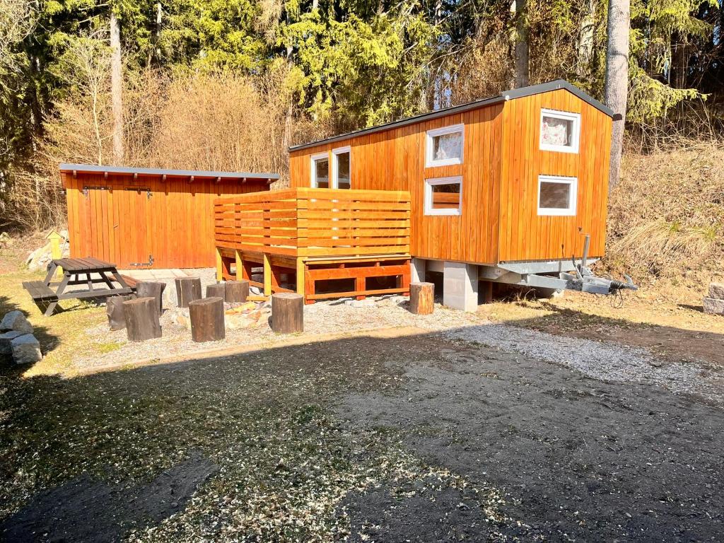 a wooden cabin with a bench in front of it at Tiny house Horní Planá in Horní Planá
