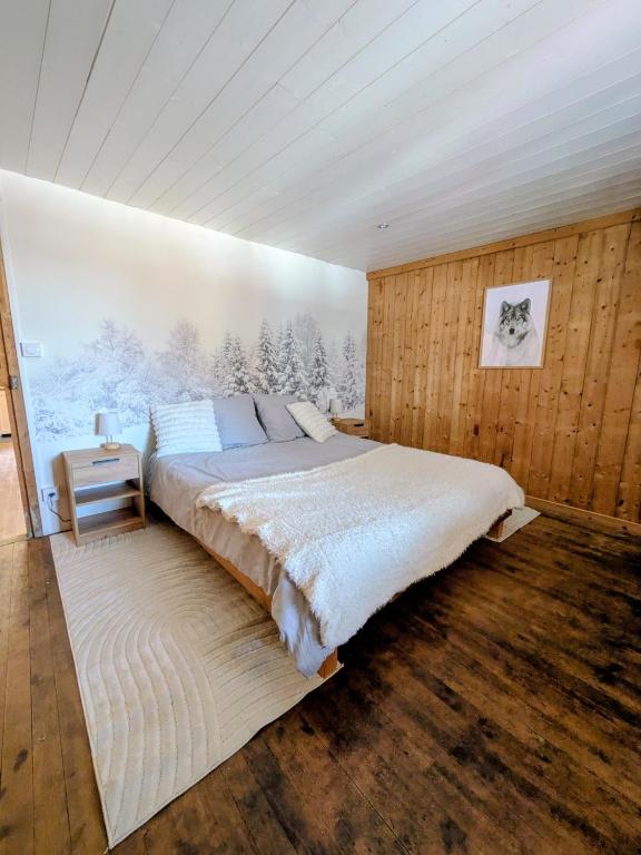 a bedroom with a large bed in a wooden wall at Le refuge de Marius - logement de colpoteur in Albiez-Montrond