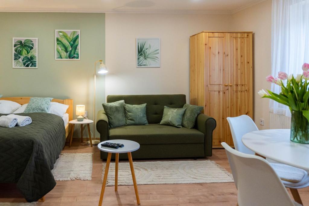 a living room with a couch and a table at BOTANIKA apartmanok Zsálya és Rozmaring in Baja