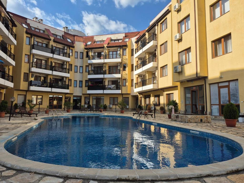 a swimming pool in the middle of a courtyard with buildings at Seaside Dream in Dolen Bliznak