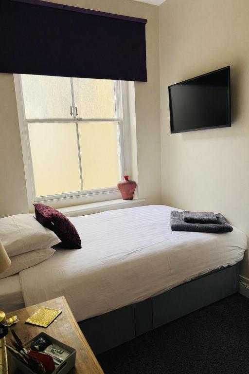 a bedroom with a large bed with a large window at Bed for the night, Close to Beach, Shops , Train in St. Leonards