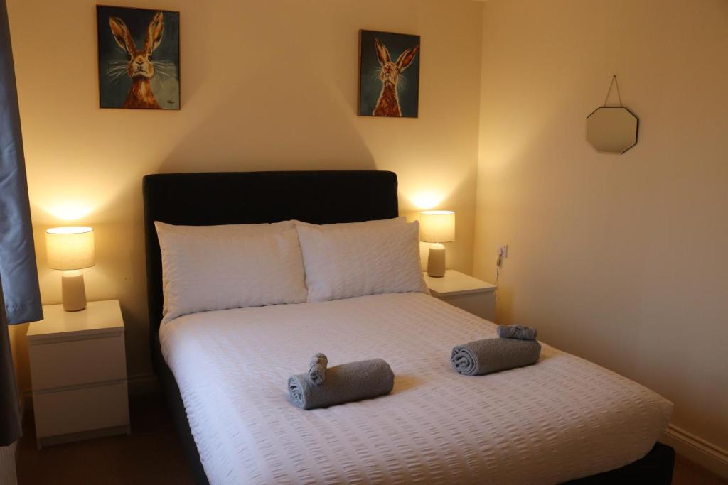 a bedroom with a bed with two stuffed animals on it at 3 Bed Home, Exeter, Devon in Countess Wear