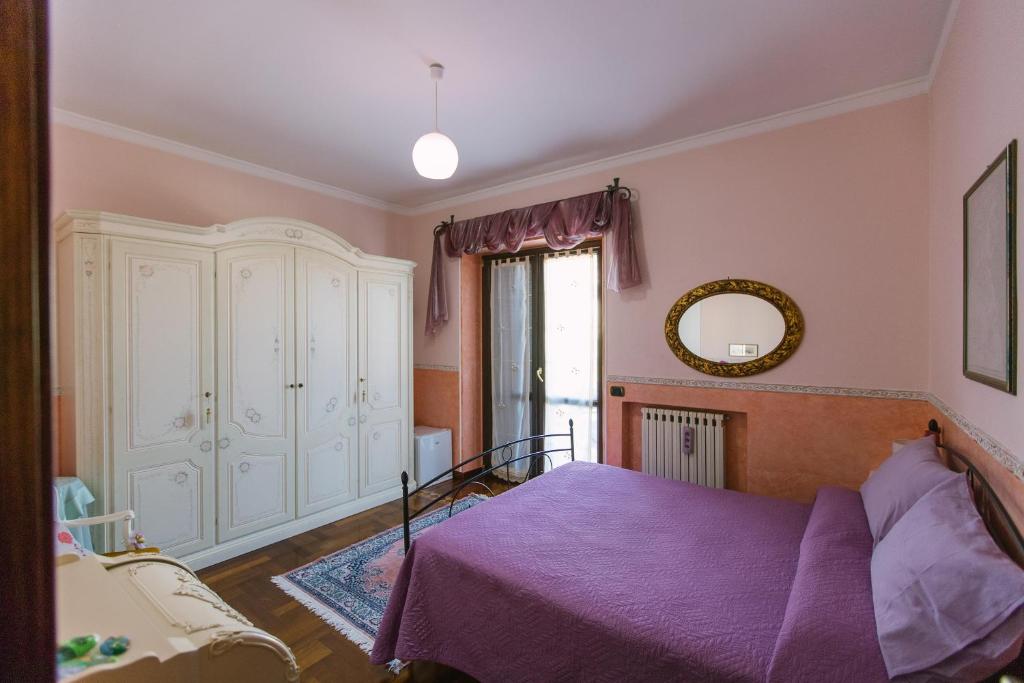 a bedroom with a purple bed and a mirror at B&B Villa Francesca in Soverato Marina