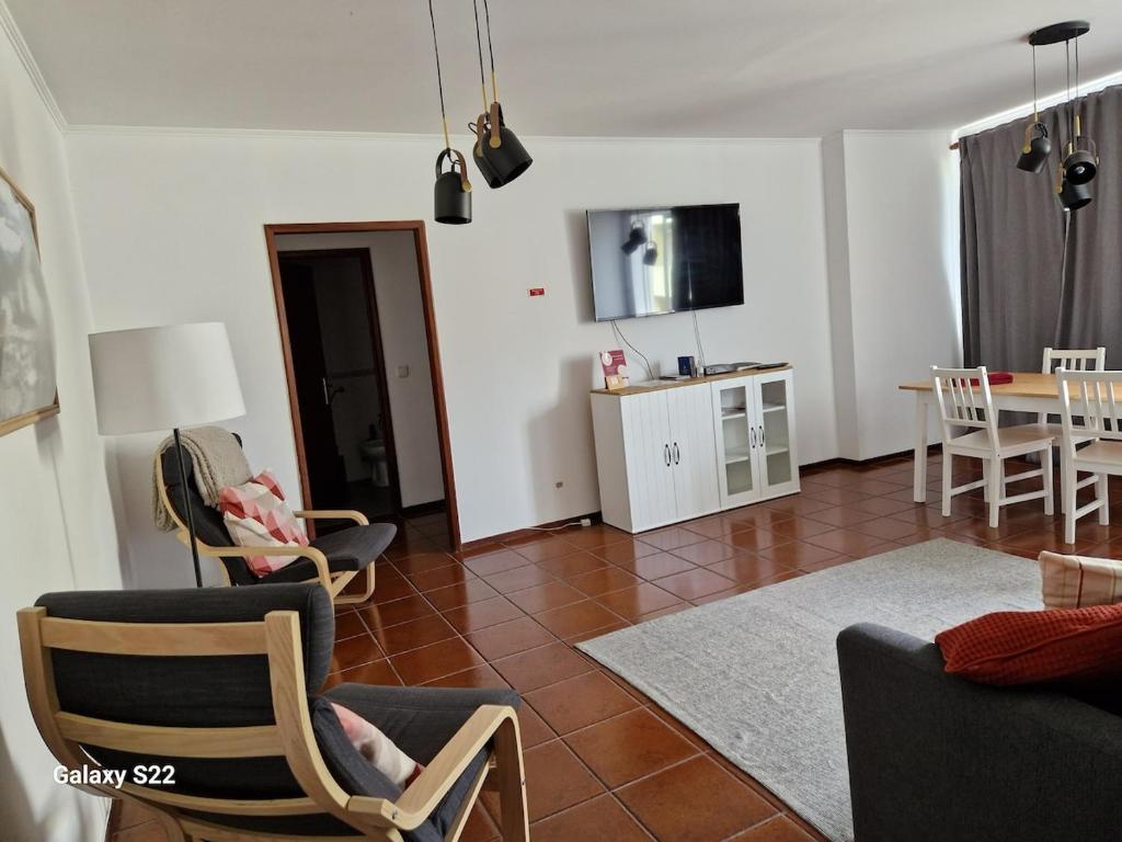a living room with chairs and a dining room at T1 Universidade Açores in Ponta Delgada