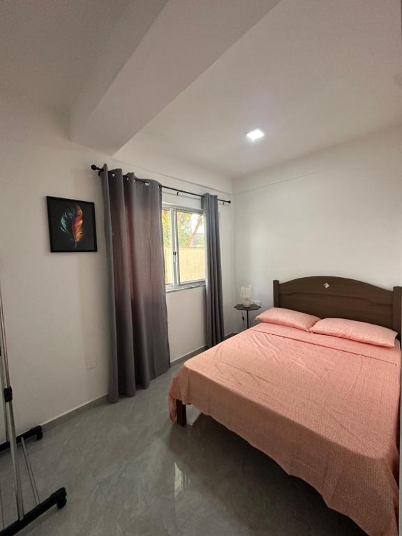 a bedroom with a bed and a large window at Quarto individual- Espaço Casa Mendes in Praia