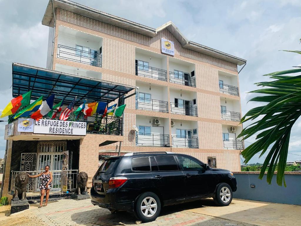 a black suv parked in front of a building at Refuge Des Princes in Douala