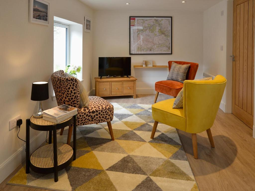 a living room with chairs and a tv at Bonnie Cottage - Uk40057 in Aberfeldy