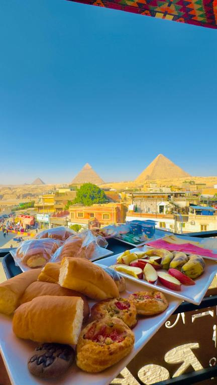 a table topped with different types of pastries on at Tua Pyramids View in Cairo