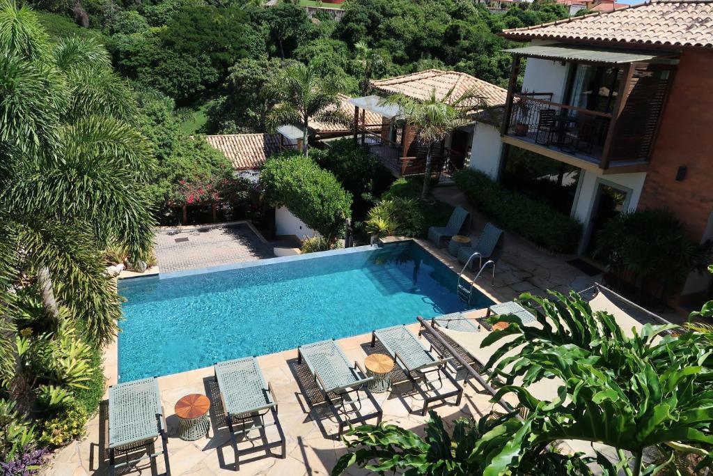 an aerial view of a swimming pool with chairs and a house at Pousada Villa Canaã in Búzios