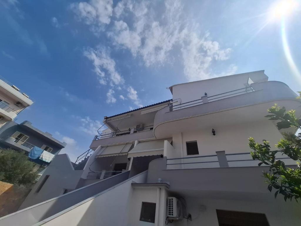 a white building with the sun in the sky at Orikum Holiday Apartaments in Orikum