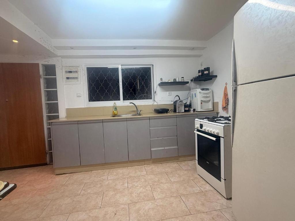 a kitchen with a refrigerator and a stove top oven at ברזיליאנו - Braziliano in Eilat