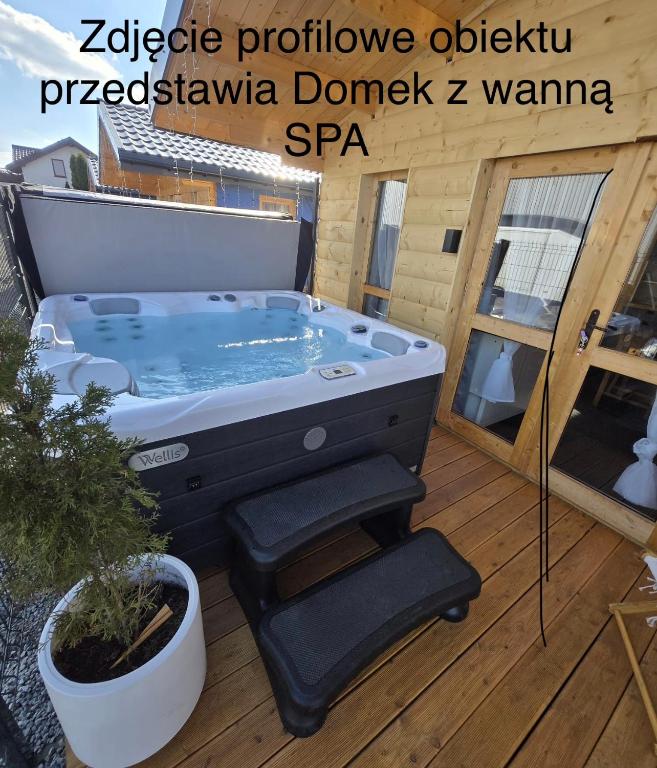 a jacuzzi tub on a deck with a plant at Noclegi AirportPark in Pyrzowice
