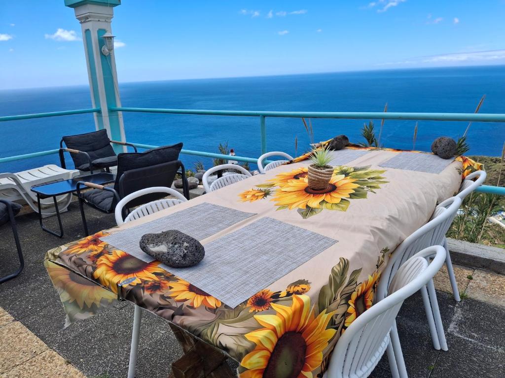 a table with sunflowers on it on a balcony at Casa d'Alegria Madeira Island in Ribeira Brava