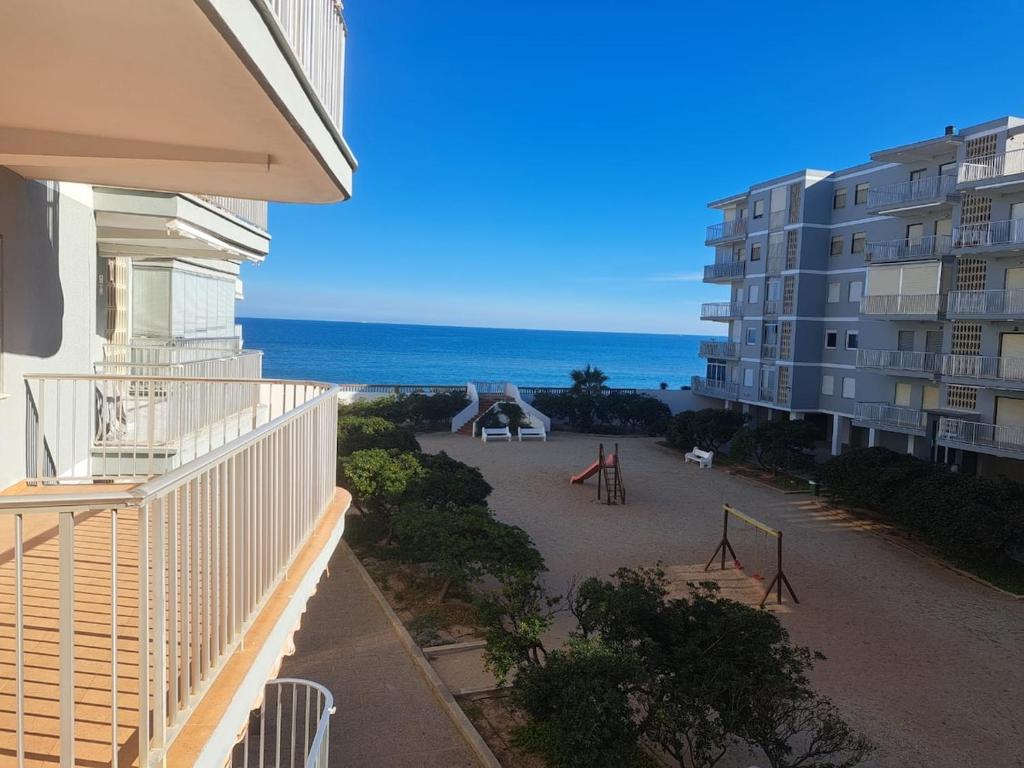 a balcony of a building with a playground and the ocean at Pet Friendly Apartment Playa Tavernes in Tavernes de Valldigna