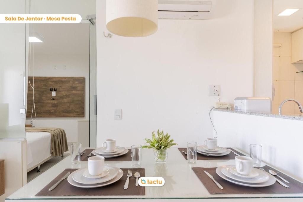 a kitchen with a table with plates and cups on it at Equipped studio with sea view VG Sun Cumbuco in Paracumbuca