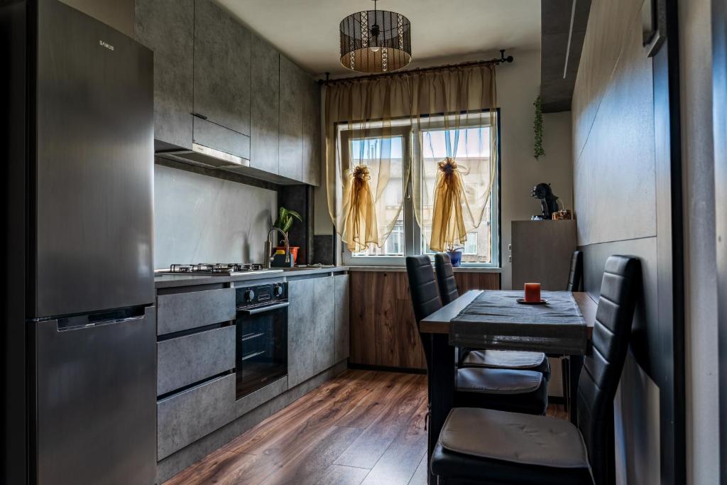 a kitchen with a wooden table and a kitchen with a stove at Apartament Deea in Orşova
