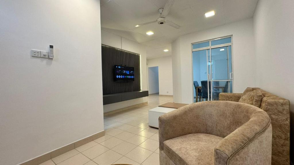 a living room with two chairs and a tv at Journy B Holiday Inn Ekala in Ekala