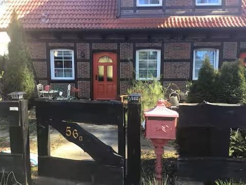 a house with a red door and a red fire hydrant at Welsh House in Siedlung Schönwalde