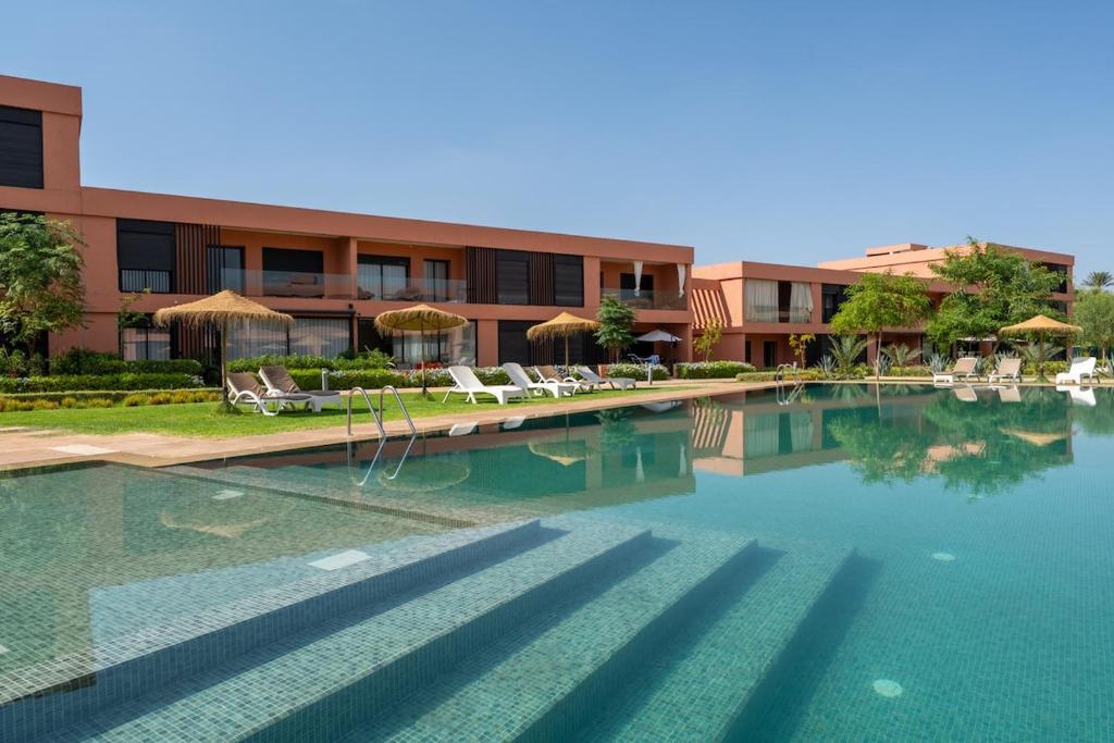 a swimming pool in front of a building at Noria Golf Apartment in Marrakesh