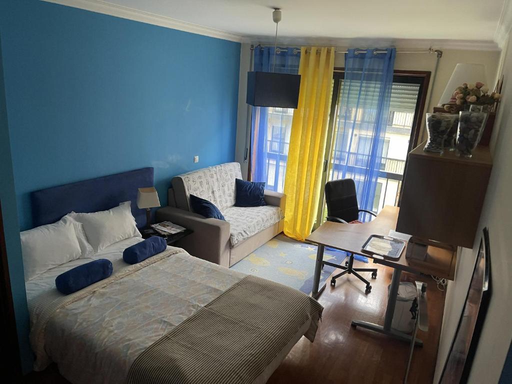 a bedroom with a bed and a living room with a couch at Quarto junto ao mar in Matosinhos
