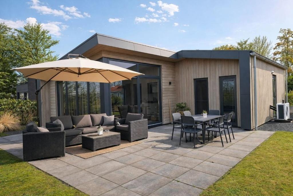 a patio with an umbrella and a table and chairs at Torenvalk 32 in Hulshorst