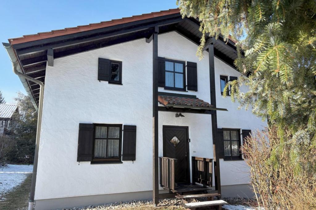 a white house with black windows and a door at Nalas Auszeit in Regen