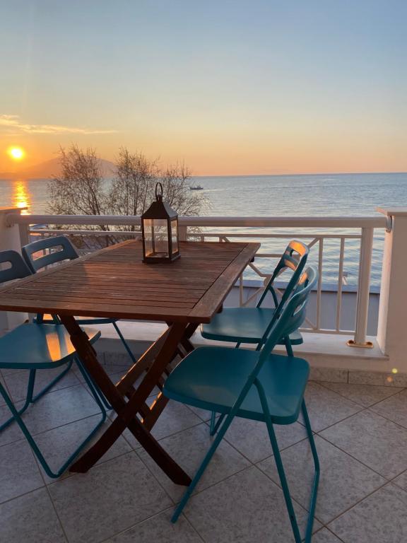 a wooden table and chairs on a balcony with the ocean at michelangela in Ireon