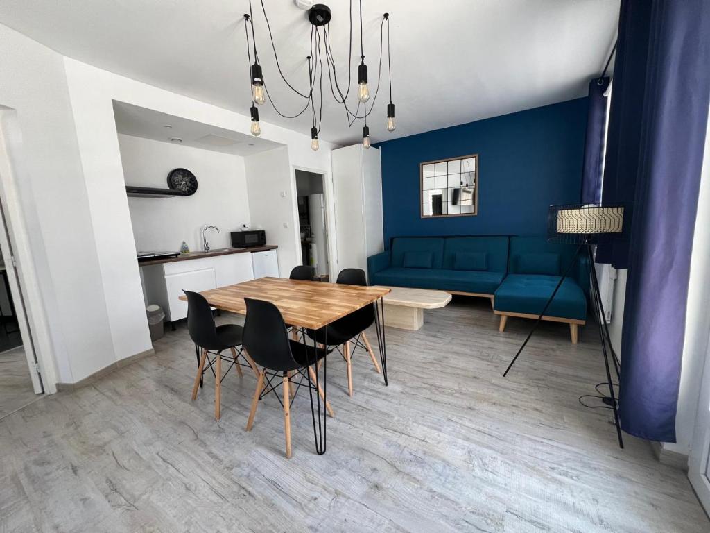 a living room with a table and a blue couch at Logement Poséidon in Boulogne-sur-Mer