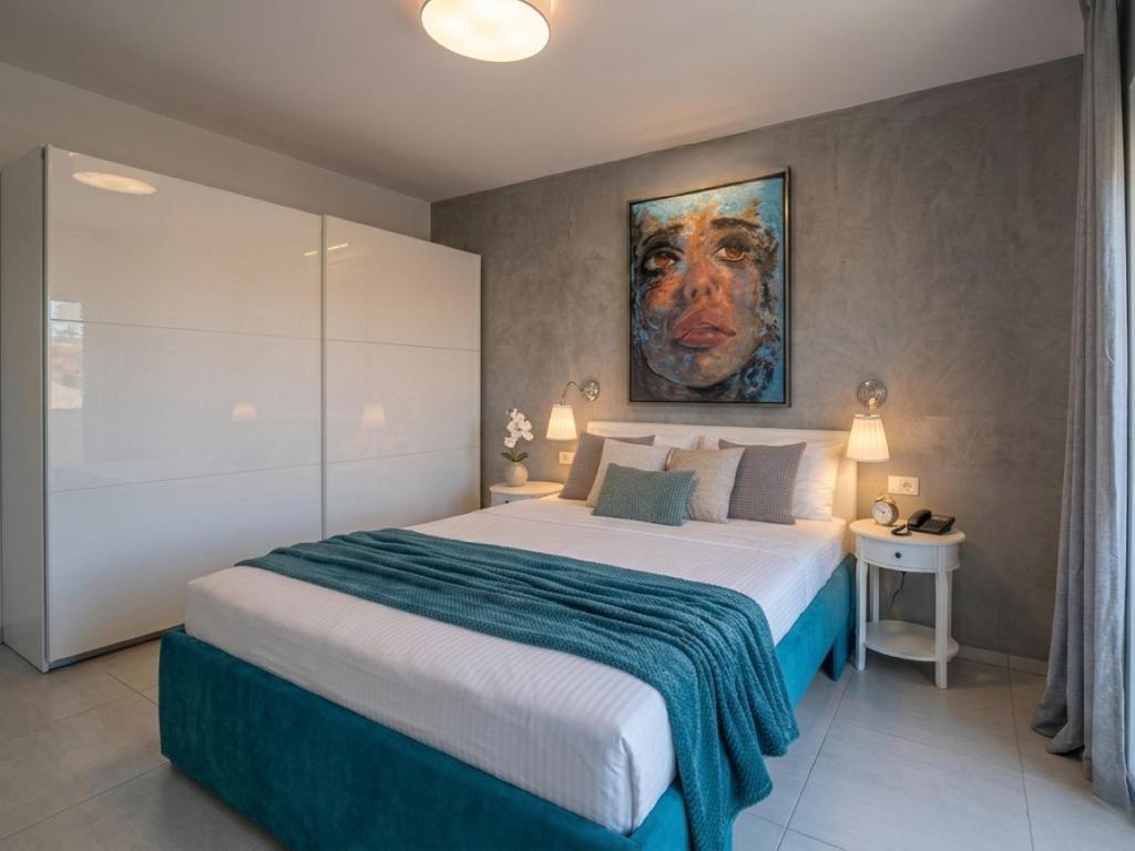 a bedroom with a large bed with a painting on the wall at Paradise for children, Family apartment Oros Medulin, with a pool, gd in Medulin