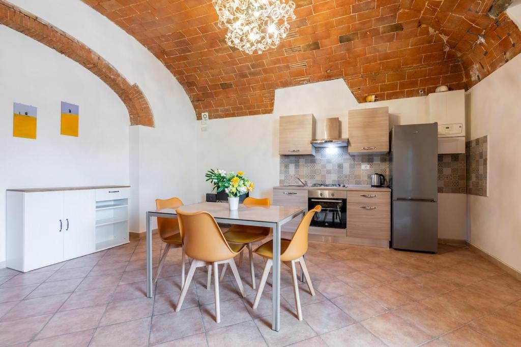 a kitchen with a table and chairs in a room at Windrose Cottage di Gio in Pisa