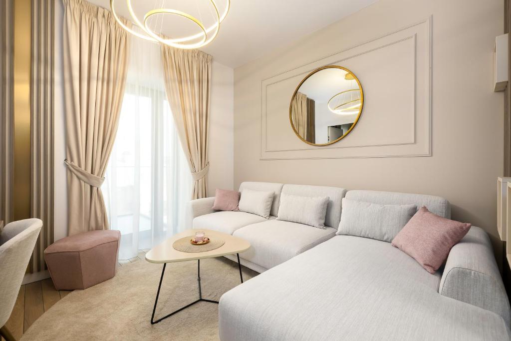 a living room with a white couch and a mirror at Best Residence - High-End Suites - by Solinis Homes in Bucharest