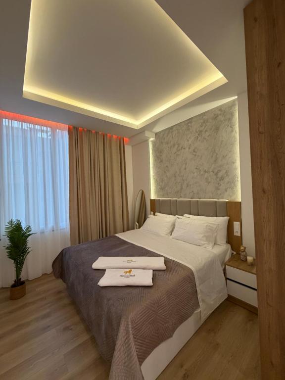 a hotel room with a bed with two towels on it at Paris and Eneas Studios in Vlorë