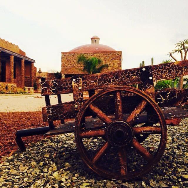 an old wooden wagon sitting on top of a rocky ground at Wellness Casa Doña Juana in Tepoztlán