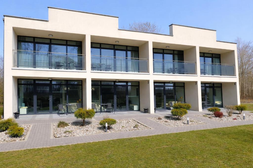 an office building with glass windows and plants at Umberto Apartamenty Dwupoziomowe Dąbki in Dąbki