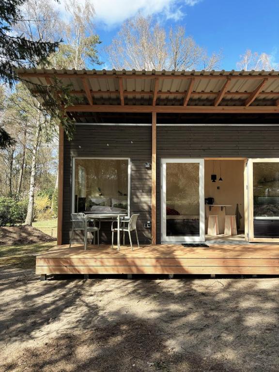 a house with a wooden deck with a table at Tiny House 1 mit Garten in der Lüneburger Heide in Soltau