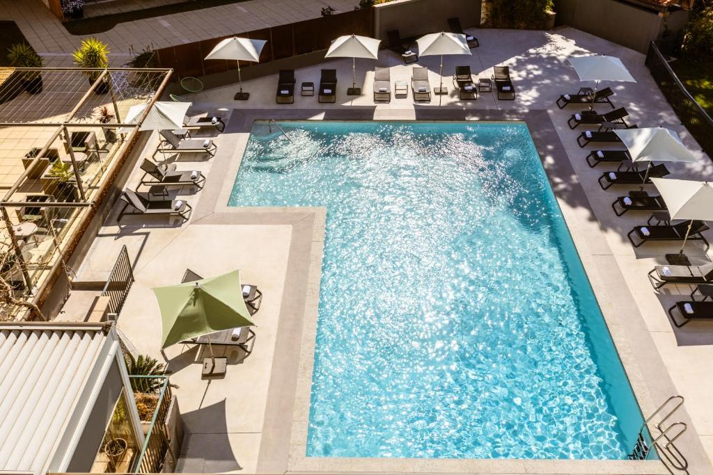 an overhead view of a swimming pool with chairs and umbrellas at Holiday Inn Perpignan by IHG in Perpignan