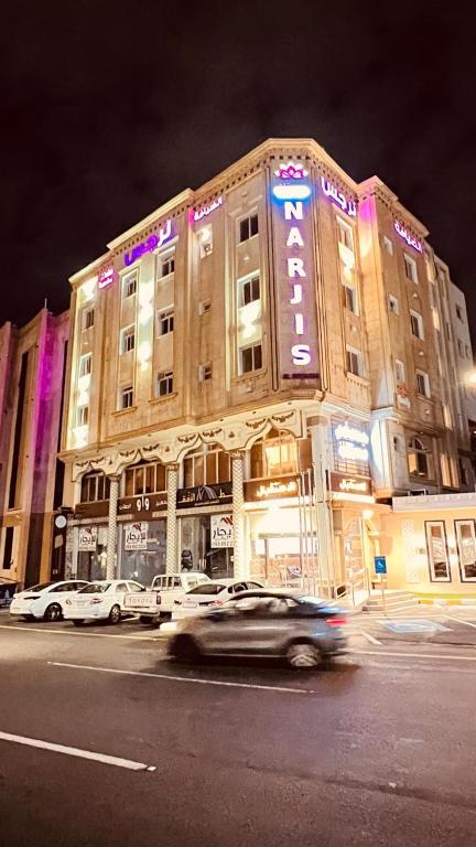 a car driving in front of a building at night at Al Deyafah Narjis-الضيافة نرجس in Khamis Mushayt