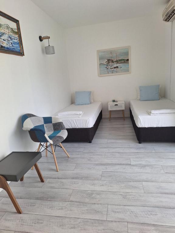 a room with two beds and a chair in it at Apartment DESi in Balchik
