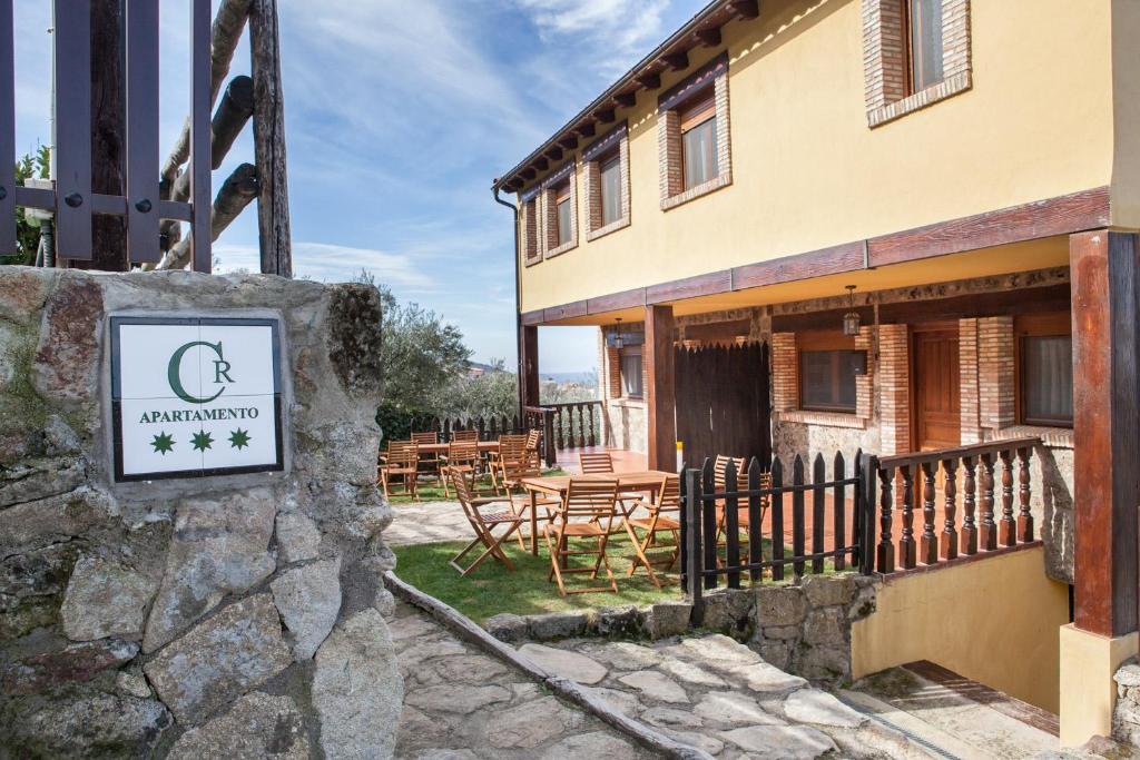 un edificio con una señal delante de él en Casas Rurales La Dehesa, en Casas del Monte