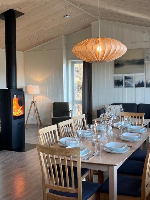a dining room with a table with chairs and a fireplace at Affordable Luxury Sauna Chalet - River Views in Vossevangen