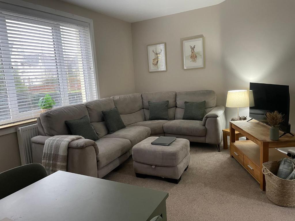 a living room with a couch and a table at West Highland Hideaway in Kinlochleven