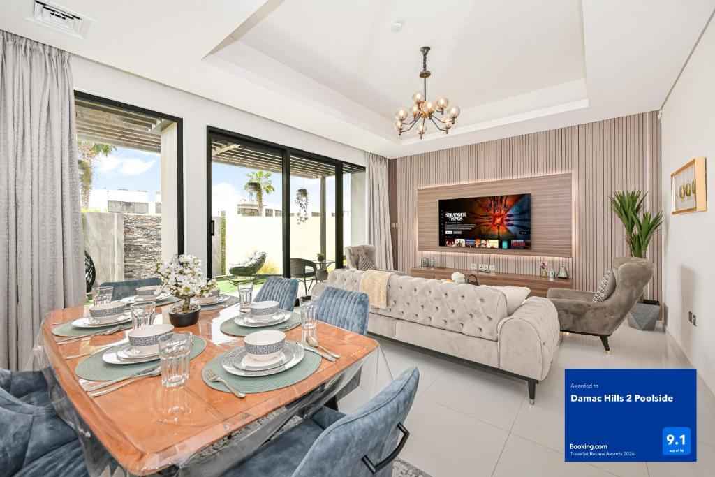 a living room with a table and chairs at Damac Hills 2 Poolside in Dubai